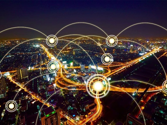 Nighttime aerial image of city with illustrated wireless connections