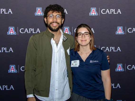 A male and female student posing in front of a backdrop during Homecoming 2024