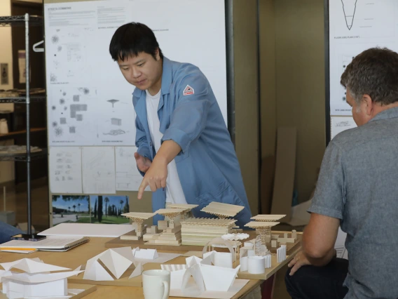 M.Arch student points at his model. 