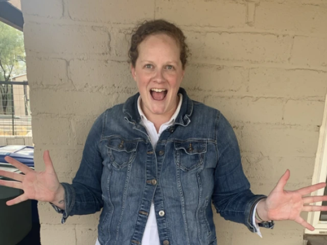 Woman stands in front of a wall