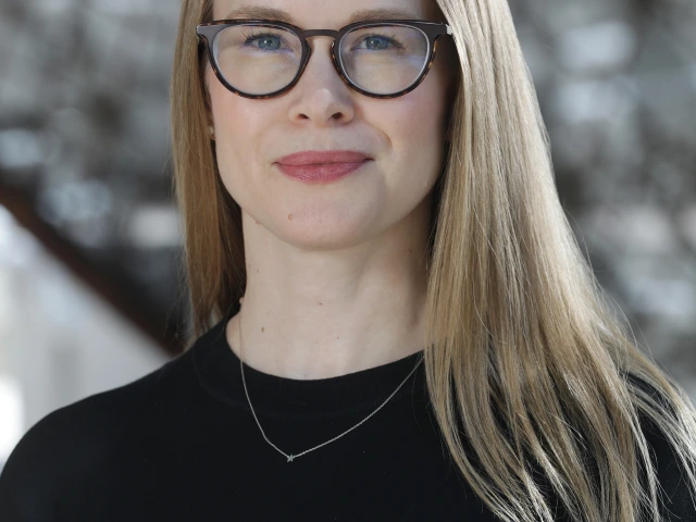 woman stands in front of gray background 