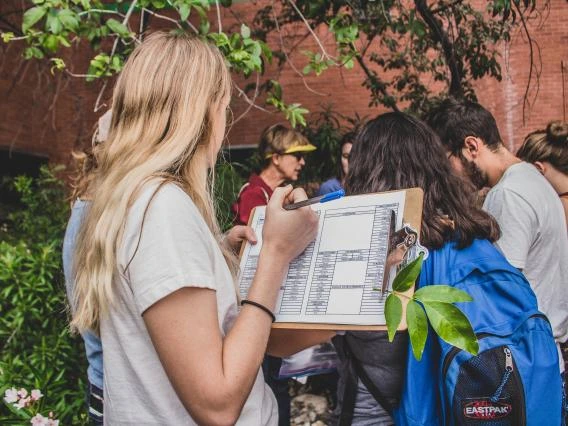 Group of Landscape Architecture students looking at plants on campus with a faculty guide
