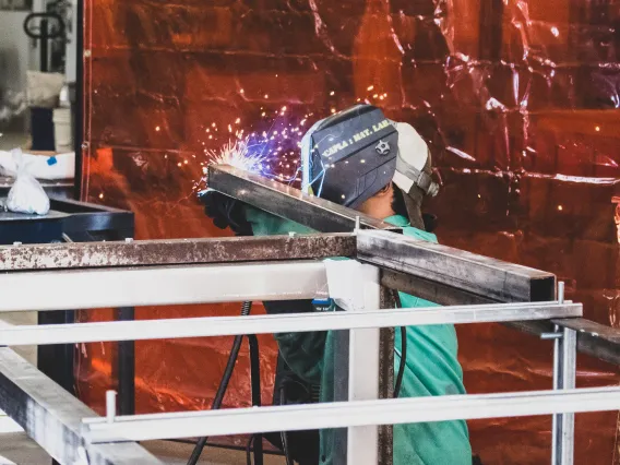 A student welding metal in the materials lab