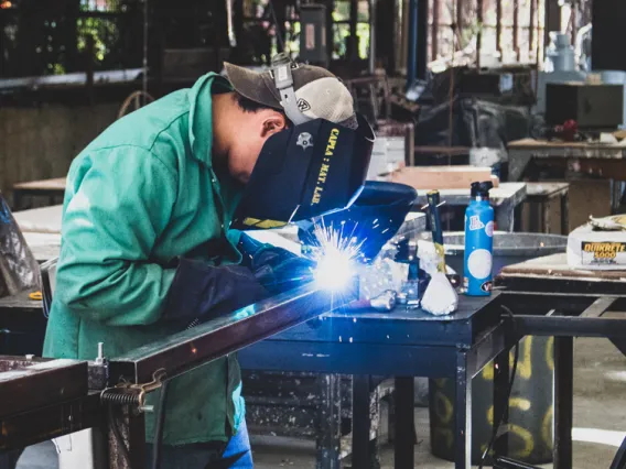 A CAPLA student welding a piece of metal on to an architecture structure