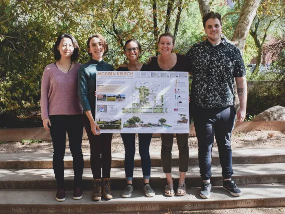 Students stand in the Underwood garden with project poster.