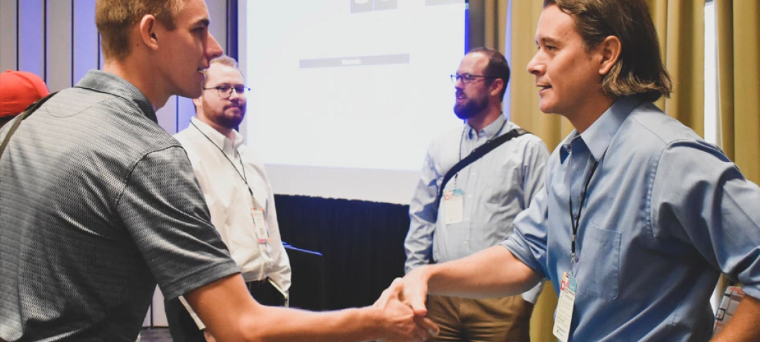 Doug Parsons shakes hands with an attendee after Podcast, Cli-Fi, and Science Storytelling for Climate Action in the Built Environment