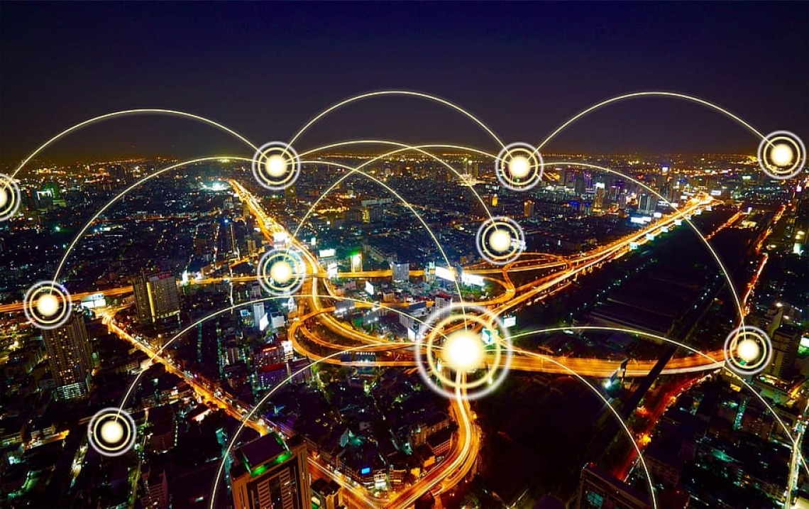 Nighttime aerial image of city with illustrated wireless connections