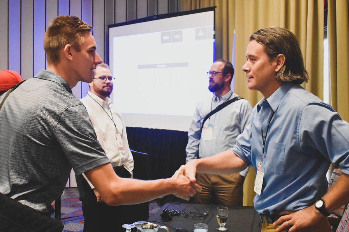 Doug Parsons shakes hands with an attendee after Podcast, Cli-Fi, and Science Storytelling for Climate Action in the Built Environment