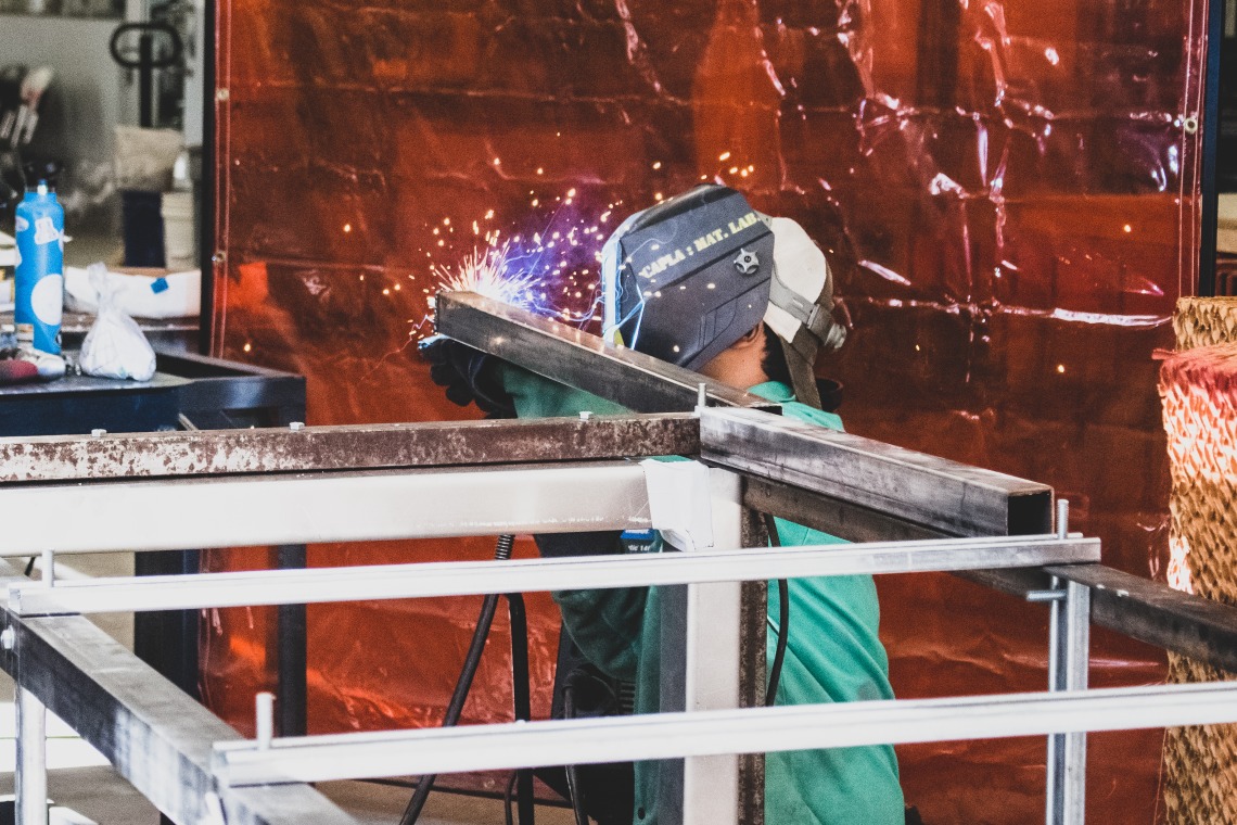 A student welding metal in the materials lab