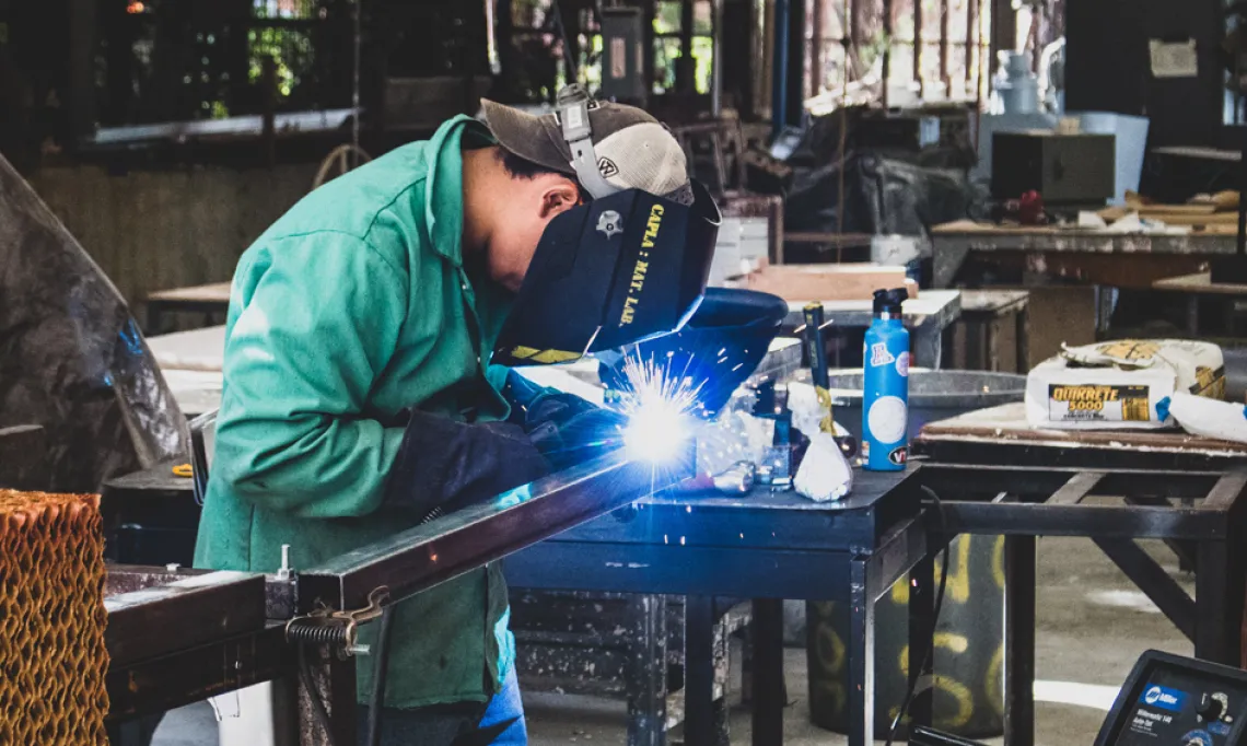 A CAPLA student welding a piece of metal on to an architecture structure