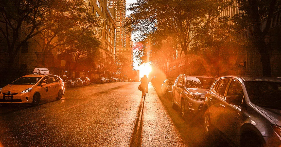 Sunlit urban street with cyclist