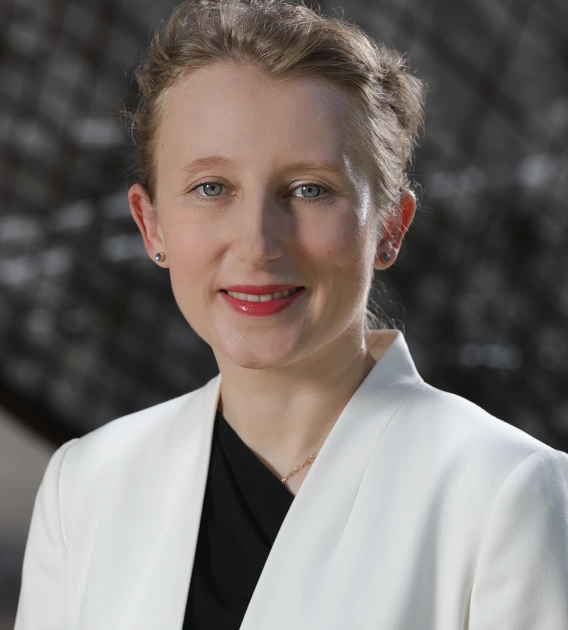 woman stands in front of gray background 