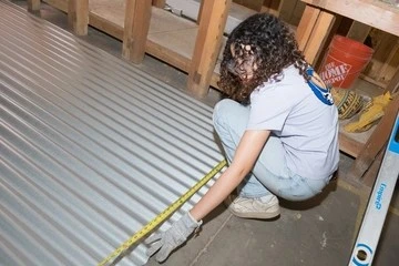 Souhayla Farag measures sheet metal.