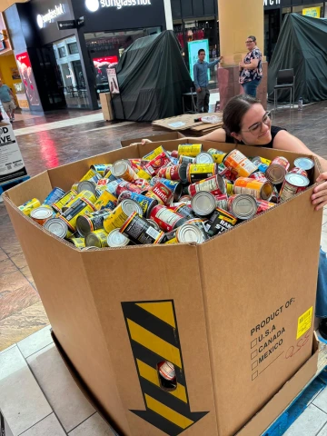 Student Hugging a Box of Cans